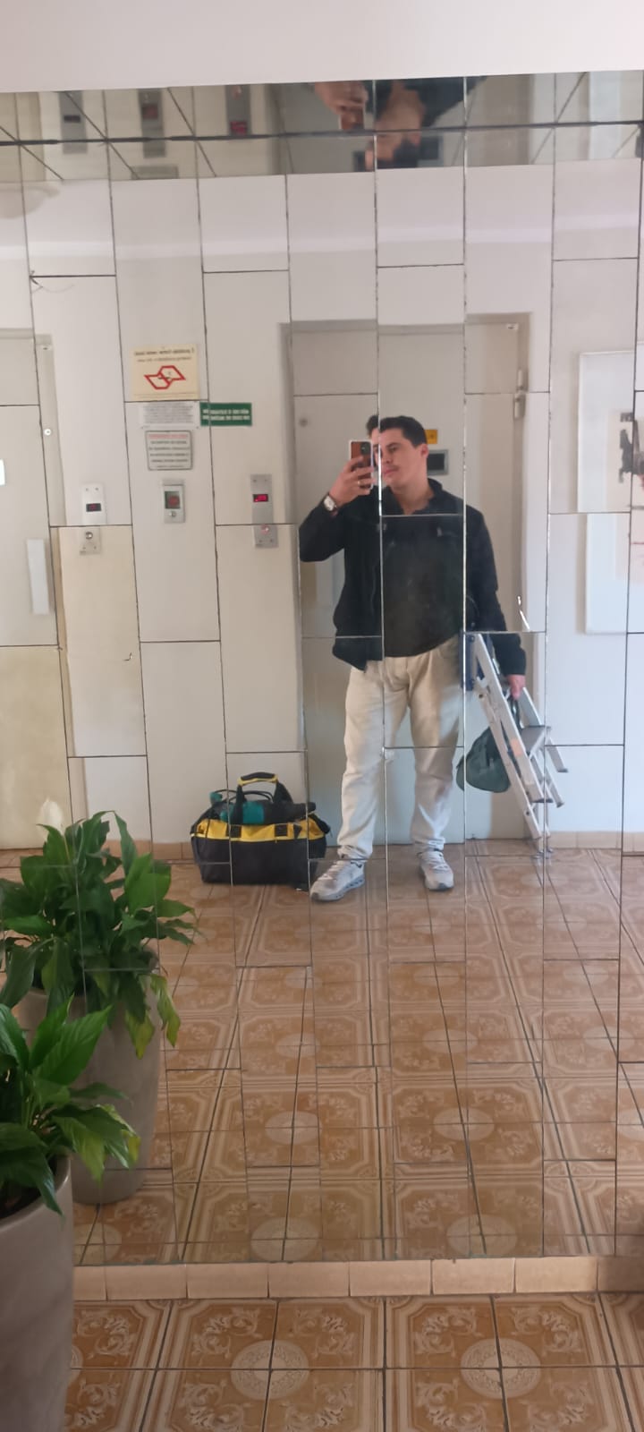 Profissional da JS Faz Tudo chegando ao atendimento com escada e bolsa de ferramentas